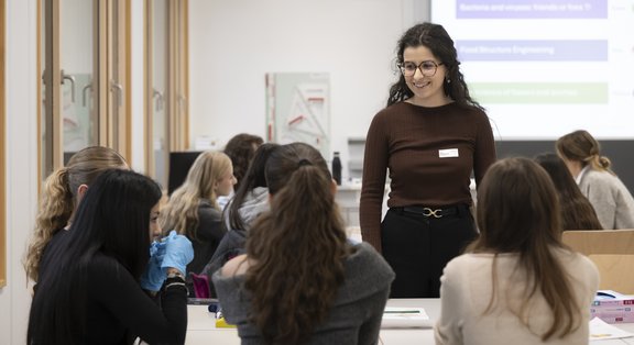 La responsabile del modulo al TecDay è in piedi davanti alla classe. Davanti a lei ci sono due file di studenti.