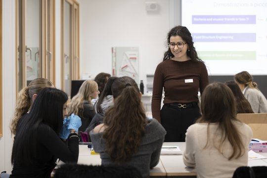 Modulverantwortliche am TecDay steht vor der Klasse. Vor ihr sind zwei Reihen mit Schüler:innen.