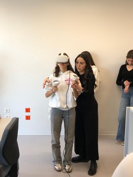 Frau hilft einer anderen beim VR Erlebnis.